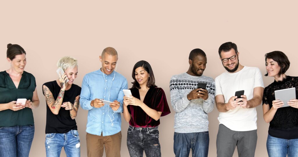 5 beneficios aplicación móvil negocio: gente diversa feliz usando dispositivos digitales